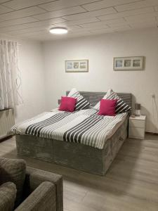 a bedroom with a large bed with two pink pillows at Schicke Ferienwohnung Philippsburg in Philippsburg