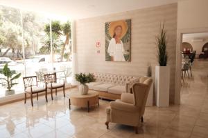 a living room with a couch and chairs and a painting at Hotel Cassandra in El Arenal