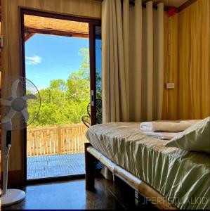 a bedroom with a bed and a sliding glass door at Jadens Guesthouse in Siquijor