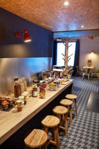 un restaurante con una barra larga con taburetes de madera en Moontain Hostel en Oz