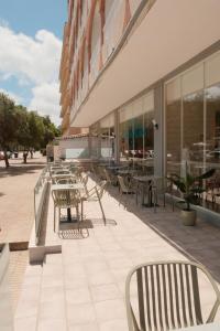 a patio with tables and chairs outside of a building at Hotel Cassandra in El Arenal