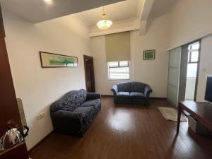 a living room with two chairs and a couch at Guangzhou Aiqun Hotel in Guangzhou