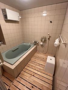 a bathroom with a bath tub and a toilet at かんぬしの宿 in Yamaguchi