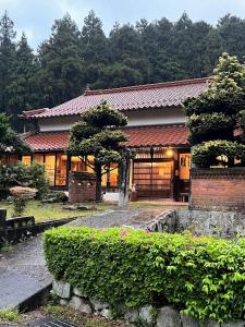 a house with a tree in front of it at かんぬしの宿 in Yamaguchi