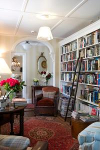 a living room with a library with book shelves filled with books at Wyett House in Greytown