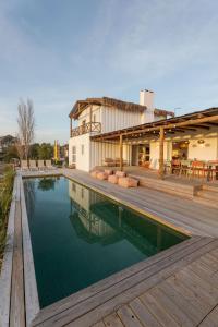 a swimming pool with a wooden deck and a building at Casa Terracotta with Private Pool in Comporta