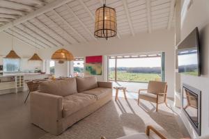 a living room with a couch and a kitchen at Casa Terracotta with Private Pool in Comporta