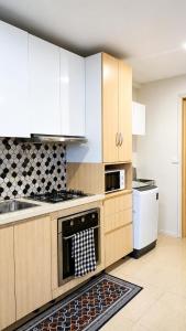 a kitchen with white cabinets and a stove top oven at The Zef Apartment in Nadi