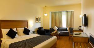 a hotel room with a bed and a living room at Abad Plaza in Cochin