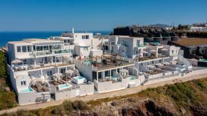 an aerial view of a large white house with the ocean at Gizis Cliffside Suites in Imerovigli