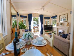 a dining room table with a bottle of wine on it at 25 Foxburrow Hang in Great Yarmouth