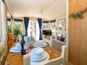 a dining room table with a bottle of wine on it at 25 Foxburrow Hang in Great Yarmouth