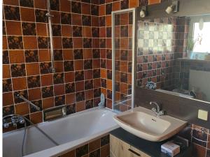 a bathroom with a bath tub and a sink at Märchenwerkstatt in Netphen +16 photos