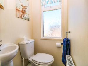 a bathroom with a toilet and a sink and a window at 25 Foxburrow Hang in Great Yarmouth +21 photos