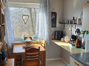 a kitchen with a table and a window at Märchenwerkstatt in Netphen