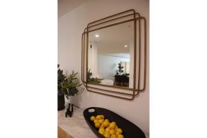 a mirror on a wall next to a bowl of fruit at Kove Apartment - G01 in Kiama