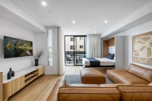a living room with a couch and a bed at Kove Apartment - G01 in Kiama