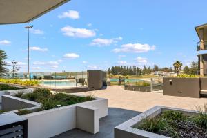 a patio with plants and a view of a building at Kove Apartment - G01 in Kiama