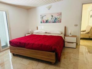 a bedroom with a large bed with a red bedspread at La Perla di Dea in Lido Di Fondi