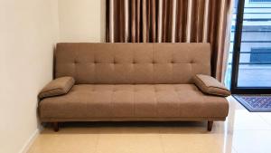a brown couch in a room with a window at The Zef Apartment in Nadi