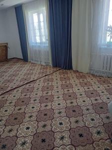 a room with a patterned floor with a window at Тумар дом in Tamga