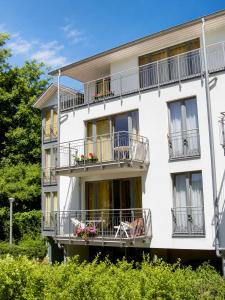 a white building with balconies and flowers on it at Haus Strandperle in Zinnowitz