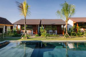 a villa with a swimming pool in front of a house at Tegal Wangi Penebel in Penebel