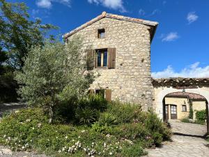 an external view of a stone house with a garden at Le Mas de Fournery in Villeneuve-de-Berg
