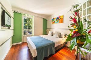 a hotel room with a bed and a tv at Hotel Exsel Alamanda in Saint-Gilles-les-Bains +20 photos