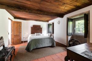 a bedroom with a bed and a wooden ceiling at Eira Country House in Ponte de Lima +17 photos