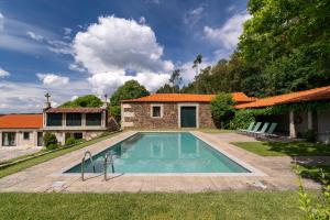 a swimming pool in the backyard of a house at Eira Country House in Ponte de Lima