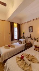 a bedroom with two beds with red roses on them at Yakamoz Hotel Fethiye in Fethiye