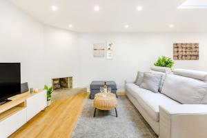 a living room with a couch and a tv at Espinho Beach 4 Stays with Terrace in Espinho