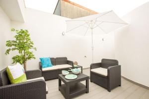a living room with two chairs and an umbrella at Espinho Beach 4 Stays with Terrace in Espinho