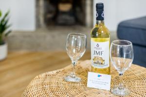 a bottle of wine and two wine glasses on a table at Espinho Beach 4 Stays with Terrace in Espinho +33 photos