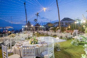 a wedding reception with white tables and chairs and lights at Villa Samudra Luxury Beachfront in Ketewel