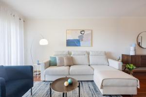 a living room with a white couch and a table at São Félix Seaside Oasis in São Félix da Marinha