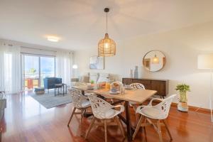 a dining room and living room with a table and chairs at São Félix Seaside Oasis in São Félix da Marinha +33 photos