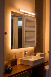a bathroom with a sink and a mirror at Jo's Apartment in Mytilene