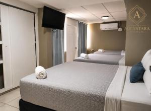 a hotel room with two beds and a flat screen tv at Hotel Alcántara Boutique in San Salvador