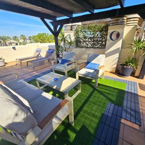 a patio with chairs and a table on a lawn at Paraíso de Roda Golf in Roda