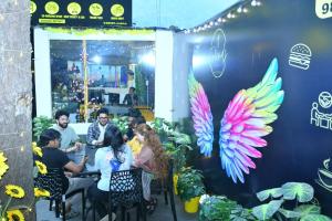 a group of people sitting at a table in a restaurant at Friends By Alizeh 2 0 Mcleodganj in Dharamshala