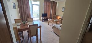 a living room with a table and chairs and a living room with a couch at Apartment SunSet rezort - sea wiew in Pomorie