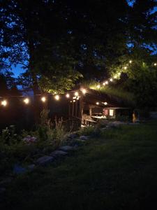 a cabin lit up at night with lights on it at Ostoja nad potokiem Dwernik in Dwernik