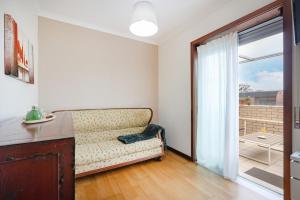 a living room with a couch and a large window at Espinho Retreat with Balcony in Espinho