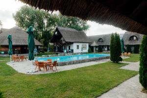 a resort with a swimming pool and tables and chairs at Hanul Pescarilor Crisan in Crisan