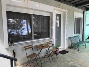 a porch with two chairs and a table and a window at Elato apartment in Florina