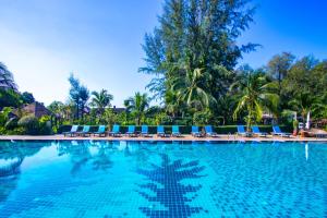 a large swimming pool with blue chairs and palm trees at Naiyang Park Resort - Beachfront Escape in Nai Yang Beach