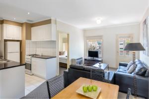 a living room with a couch and a table at Hawthorn Gardens Serviced Apartments in Melbourne