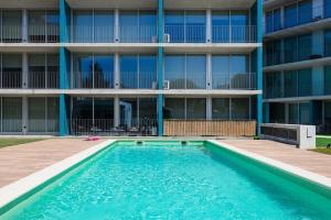 a swimming pool in front of a building at Blue Breeze Espinho | Pool View, Gym & Balcony in Espinho